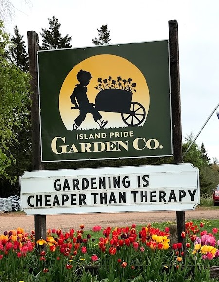 Island Pride Garden Co sign with message "Gardening is cheaper than therapy"